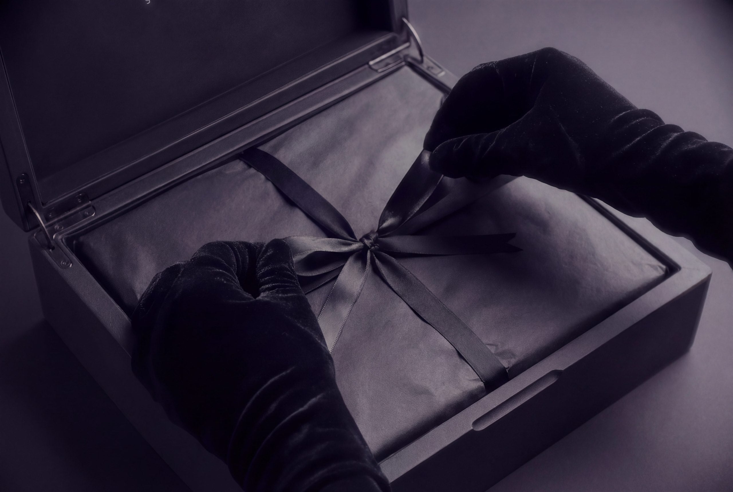 Open presentation with ribbon and gloved hands