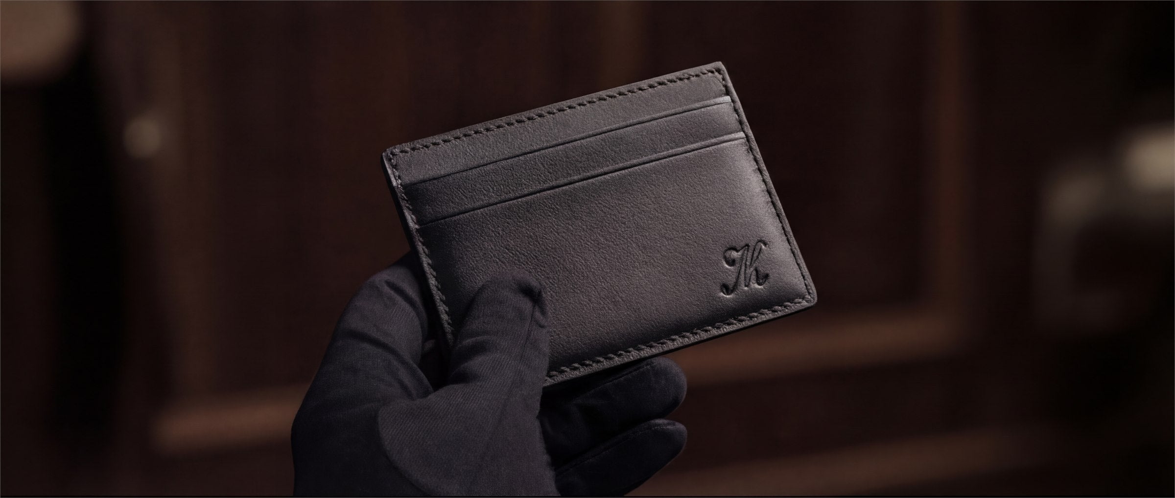 A finished personalized cardholder held in a gloved hand.