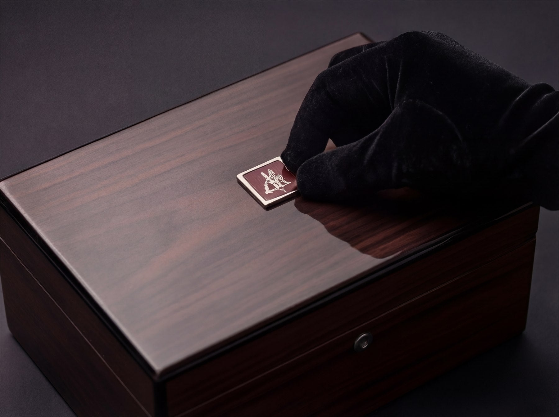 A house plaque being placed on a presentation box.