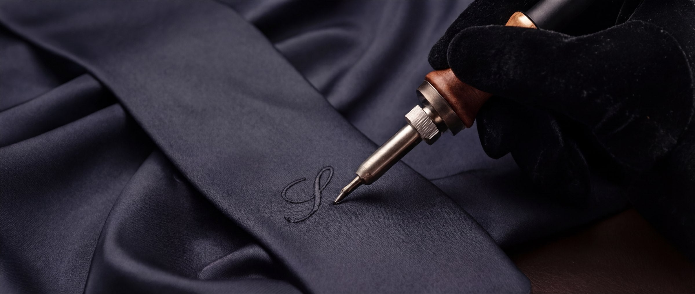 Script embossing being applied to a personalization detail.